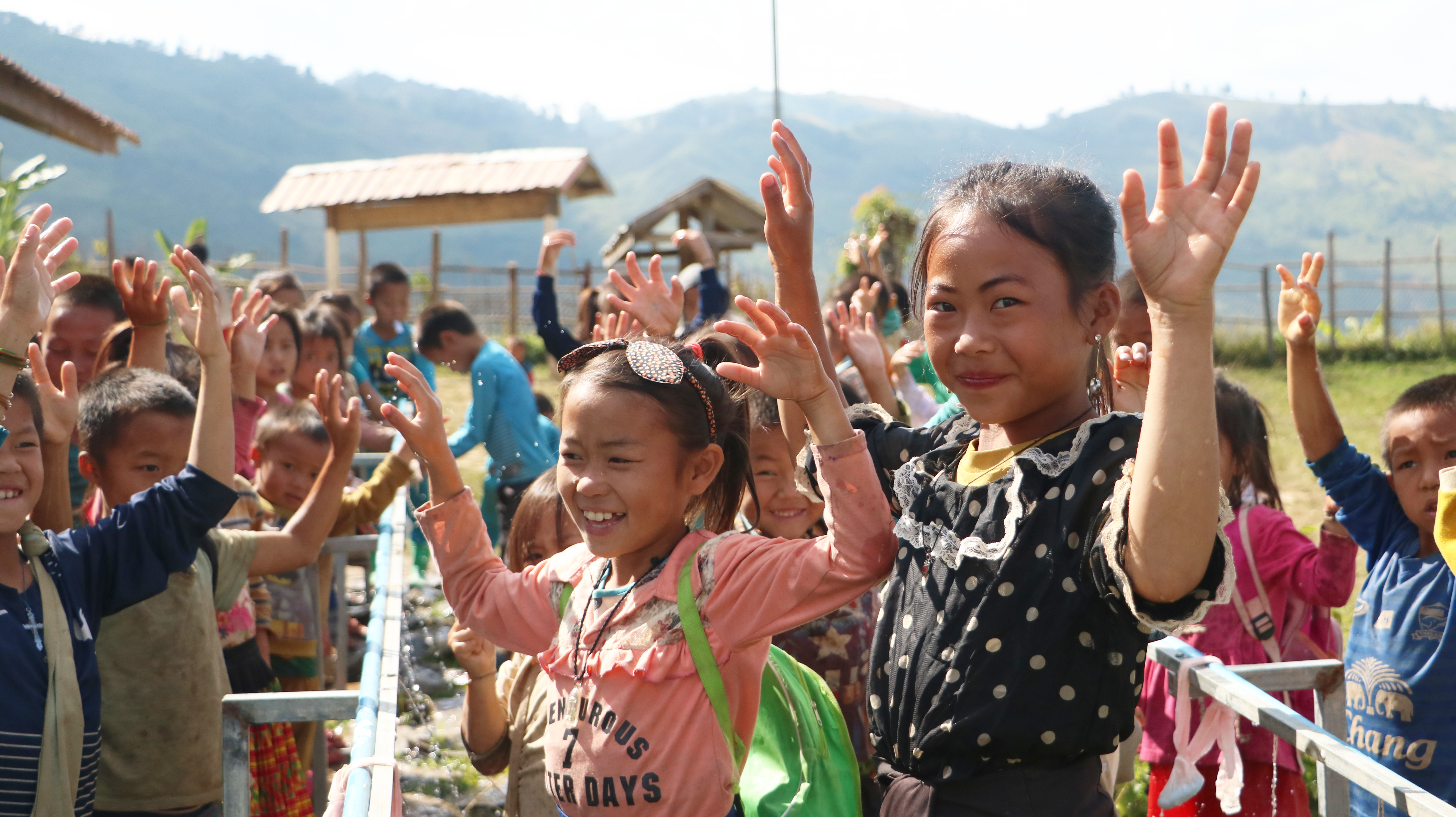 Meisjes wassen handen in Laos
